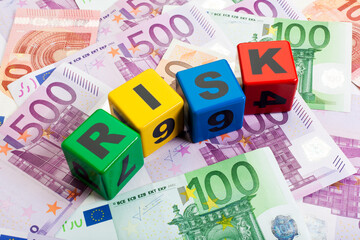 Risk spelled with spelling blocks upon European currency notes