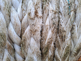 ship ropes in the harbor. Frayed boat rope. Massive nautical dirty shabby white ropes background texture close up. Selected focus of ropes. Close up pattern dirt Old ship ropes. Texture	
