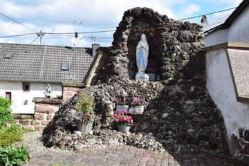 religious cave building with a white holy mary statue