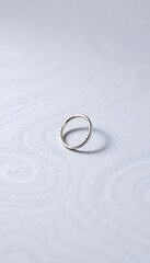 silver ring sitting on top of a white surface