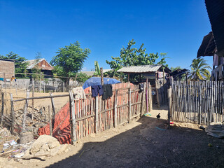 Charming fisherman’s house in a rural village, surrounded by a bamboo fence under the bright sun.