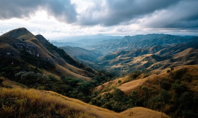 Naklejka premium Mountain valley landscape at dawn; scenic view of hills and valleys with golden grasses, perfect for nature photography, travel or wallpaper