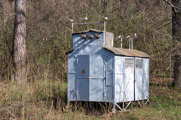 Retro transformer substation in a forest environment. Concept illustration of power supply...