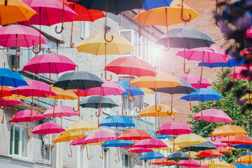 A street decorated with brightly colored umbrellas. A festive and colorful composition that conveys...