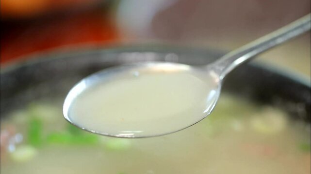 Scooping up ox bone soup with a spoon