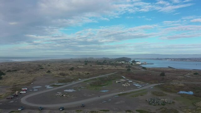 Drone follows a person riding an off-road motorcycle at Samoa Dunes Recreation area in Eureka, California. Aerial view.