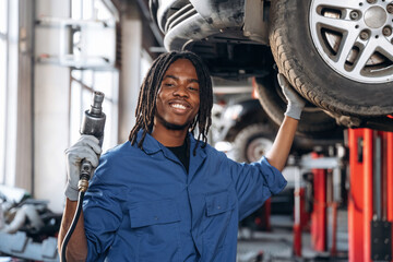 Tire needs to be changed. Male mechanic is with car in garage