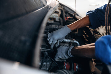 Fixing the automobile, under the hood. Male mechanic is with car in garage