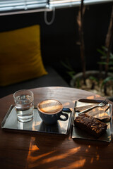 Hot coffee latte with latte art milk foam in cup mug and Homemade Brownie on wood desk on top view. As breakfast In a coffee shop at the cafe,during business work concept,vintage style