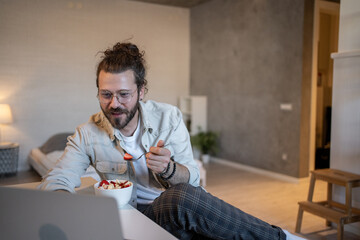 Freelancer enjoying fruit salad while working from home on laptop