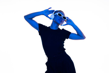 Fashionable woman dancing in a studio with blue light and futuristic style