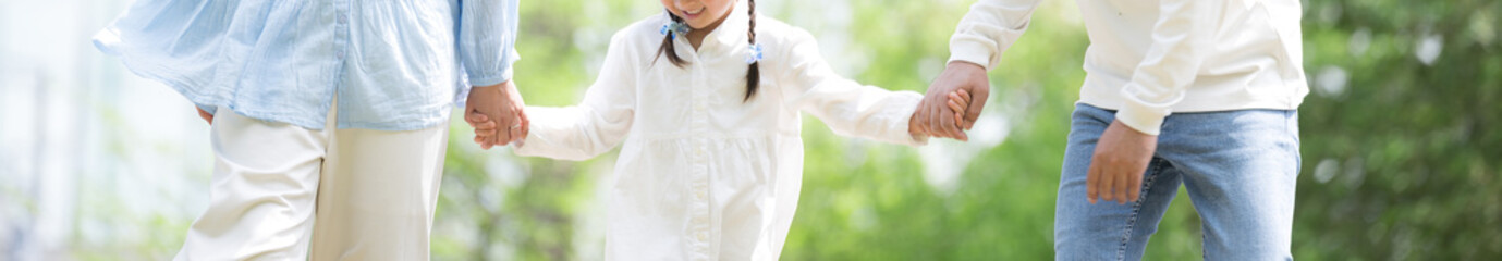 Faceless banner with image of spring and summer outings and outdoor recreation with families walking hand in hand with smiles on their faces