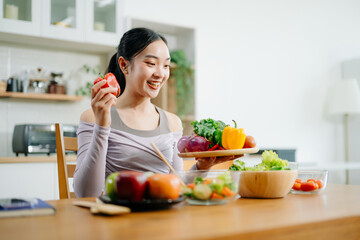  Young female in kitchen and writing down healthy recipe or daily ration diet at home. Active...