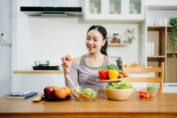  Young female in kitchen and writing down healthy recipe or daily ration diet at home. clean eating concept.