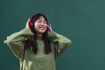 Young woman enjoying music with headphones on a street