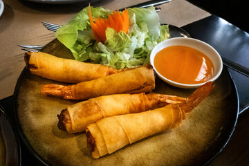 Khung phom pha, prawn tail rolls in a rice wrapper, a dish at a Thai restaurant, with a sweet sauce