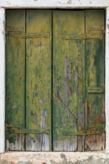 Old green wooden shutters with peeling paint