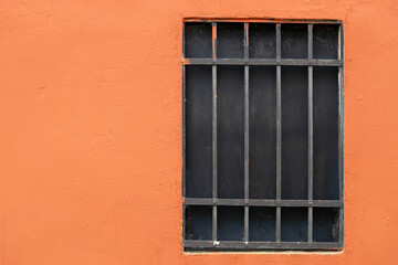 Fototapeta premium Simple iron barred window on orange wall