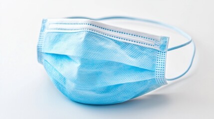 Surgical mask placed on a light background, symbolizing health measures during a pandemic