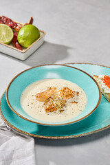 Creamy Fish Soup with Scallops on Elegant Turquoise Plate in Bright Studio Lighting