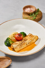 Grilled coal fish fillet and cod with vegetables and bisque sauce, natural light, minimal plating