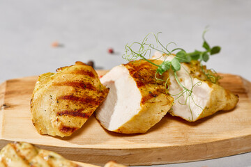 Grilled chicken fillet on rustic wood board, natural light, minimalist composition