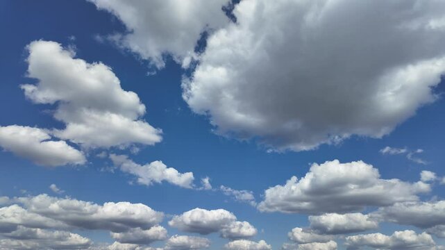 Timelapse of soft white clouds moving on clear blue sky