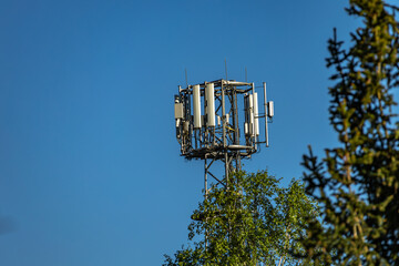 Cellular telephone antenna against a blue sky background,