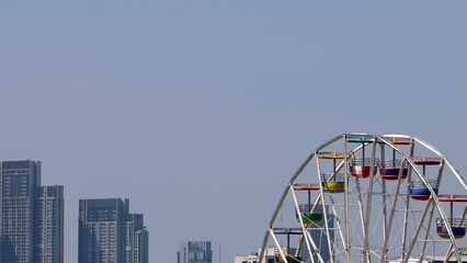Bright Ferris Wheel Against Skyline and Clear Sky