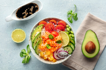 Poke bowl with salmon. Hawaiian salad with rice, fish, tomato, and avocado. Healthy diet. Overhead flat lay shot with ingredients