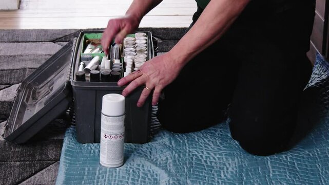 Camera follows technician stowing gear and closing toolbox on hallway floor