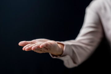 Fototapeta premium Businesswoman holding something or showing a blank area for the sign on her hand. Copy space. Business concept