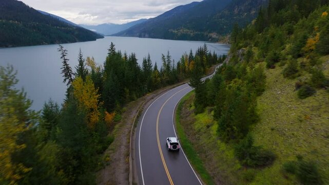 landrover defender driving down a highway in the mountains of British columbia
