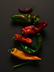 Different peppers over brown background