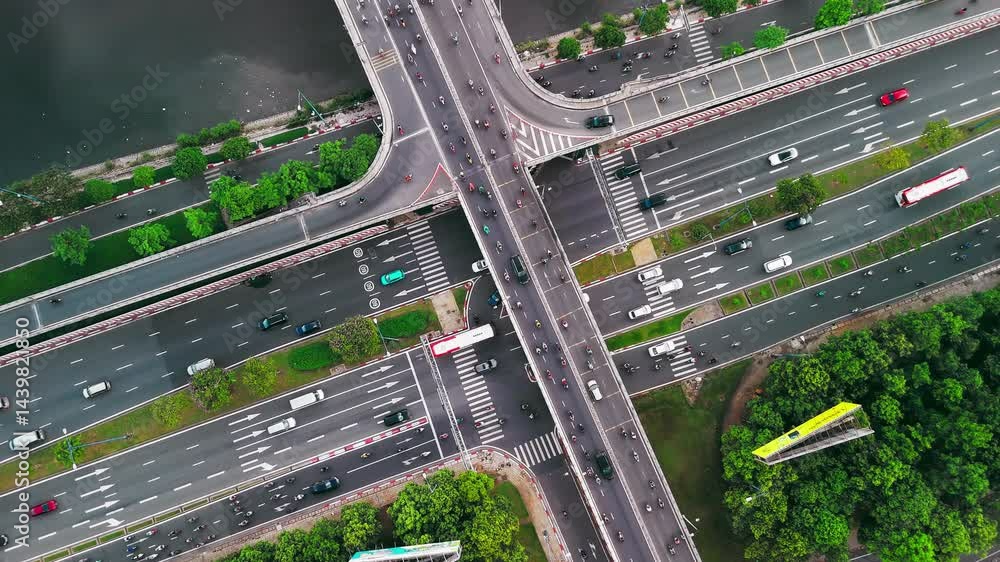Poster dynamic time-lapse of a highway junction from above, capturing the flow of traffic and urban energy.