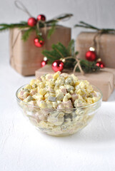 Traditional Russian salad in a deep transparent plate.