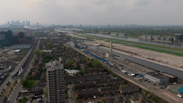 Drone flight towards London City Airport on cloudy Spring day, with city skyline