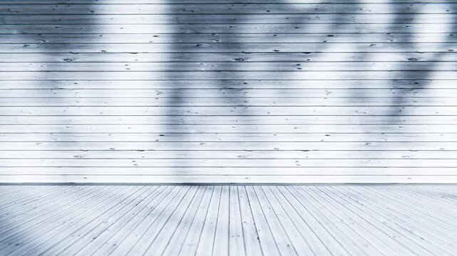 Natural light creates shadows on the wooden walls of an empty room