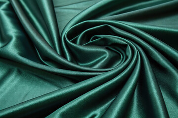 Obraz premium Dark emerald green silk satin fabric background.