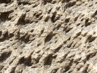 Rough textured stone surface with natural erosion patterns