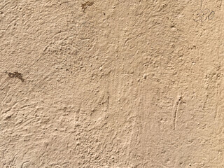 Textured beige wall surface with rough pattern and natural imperfections