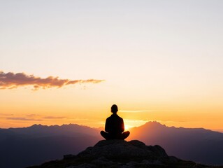 Person meditating on mountain at sunrise