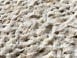 Close-up texture of swiss cheese with visible holes and creamy surface