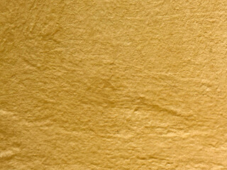 Textured yellow paper surface with natural wrinkles and folds