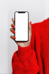Hand holding a smartphone with empty screen, showcasing vibrant red sweater for stylish outfit inspiration