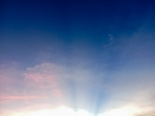 Beautiful evening sky showcasing a stunning gradient of blue to pink hues with soft clouds and subtle sunrays.
