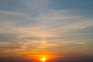 Background with sky at sunset. Red sun sets over the horizon.