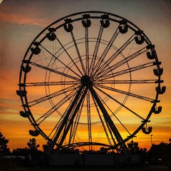 Vintage Ferris Wheel Silhouette at Sunset. Retro amusement park scene, dramatic orange sky, aged paper texture background. Nostalgic summer evening.