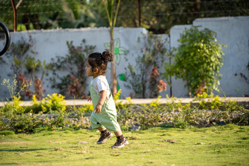 Little kid playing in garden area or park	