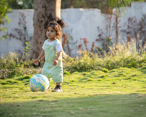 Little kid playing in garden area or park